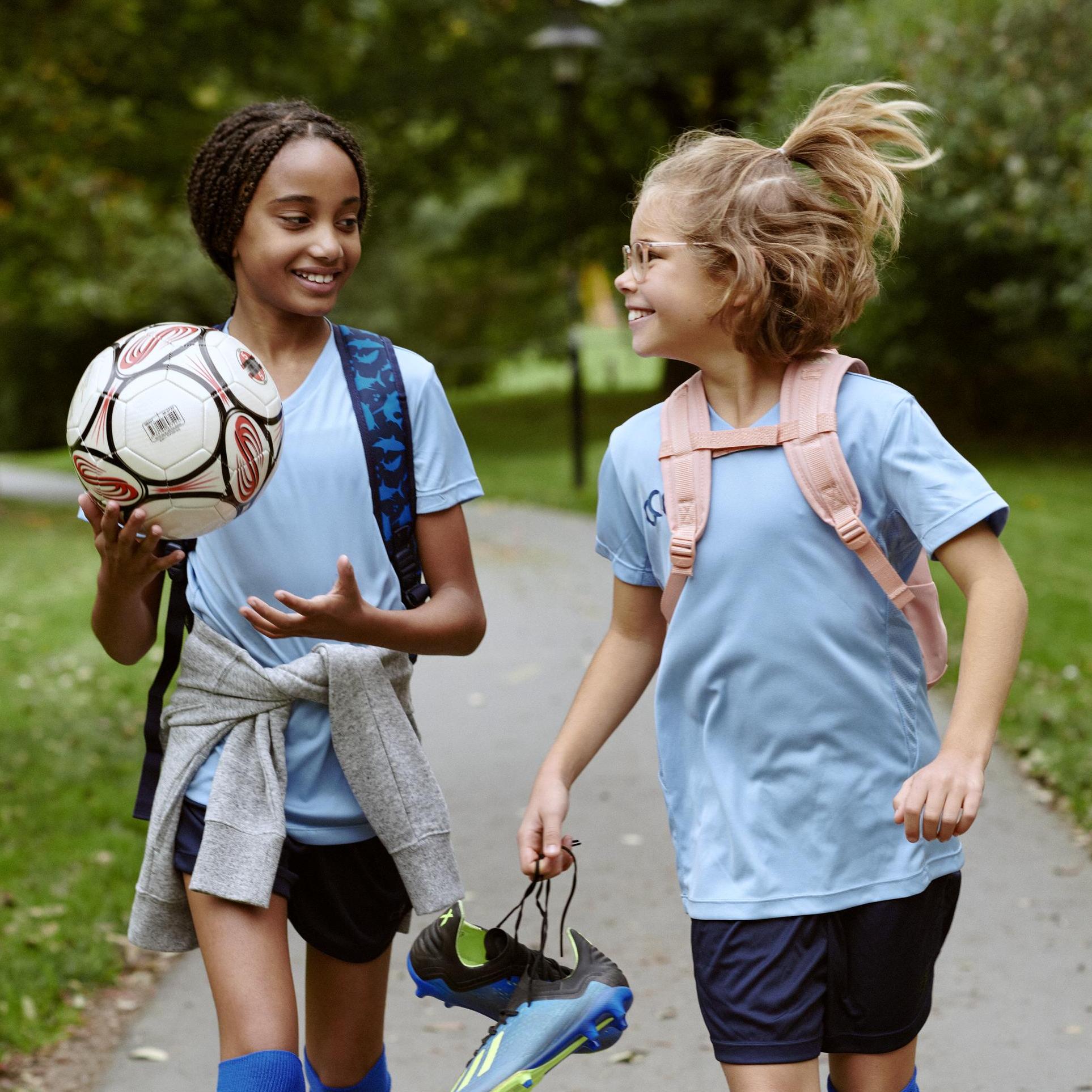 Two kids walking to soccer practice 