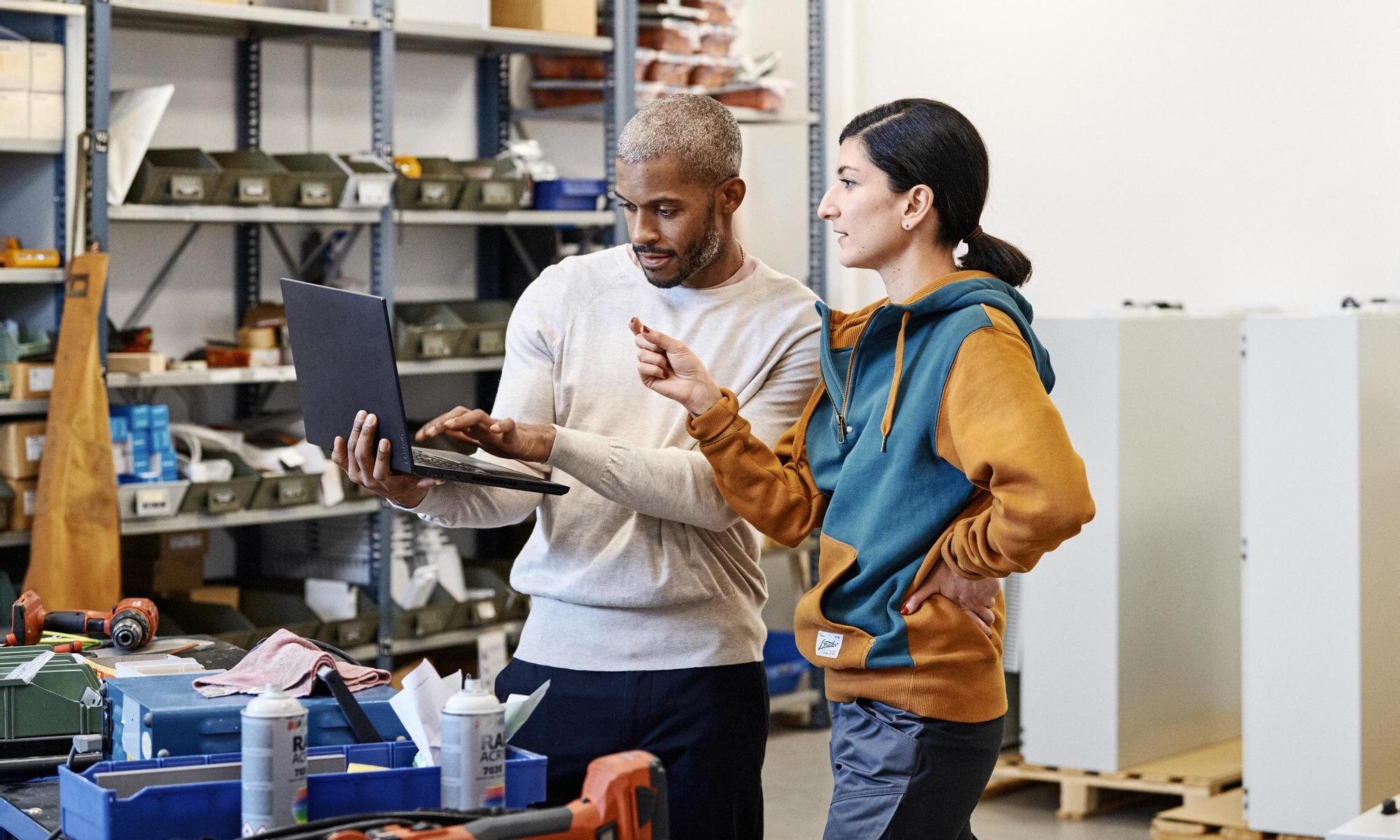 Discussion between two colleagues. Man holding a computer 