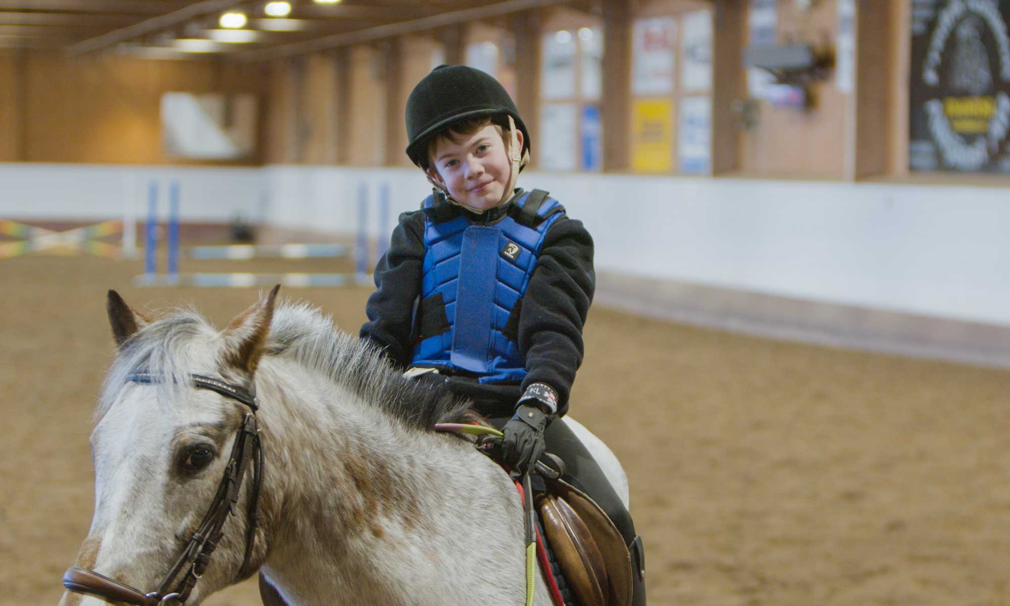 pojke rider på vit häst