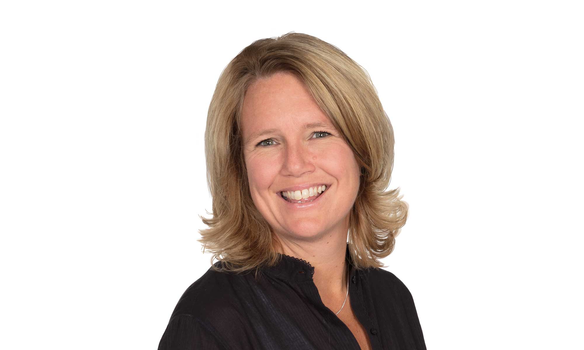 a woman with blond hair and a white shirt is smiling into the camera