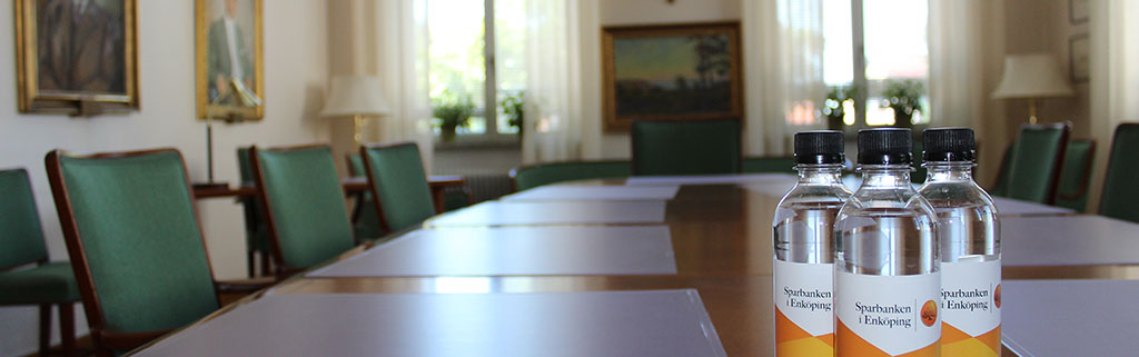 Boardroom with green chairs and bottles of water